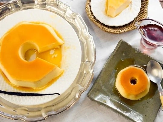 Un flan de maracuyá grande y otro pequeño servidos en dos platos sobre una mesa
