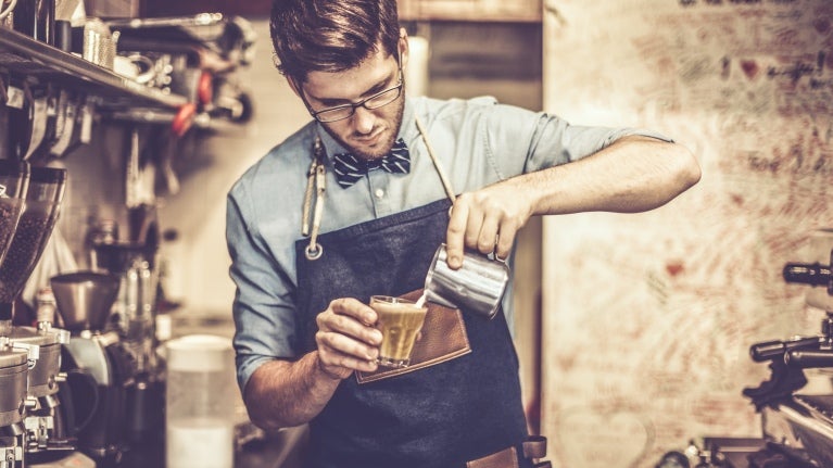 Joven barista preparando un café