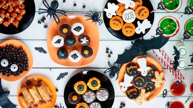 Vista en ángulo alto de varios postres decoradas para una fiesta de Halloween acordes con la temática