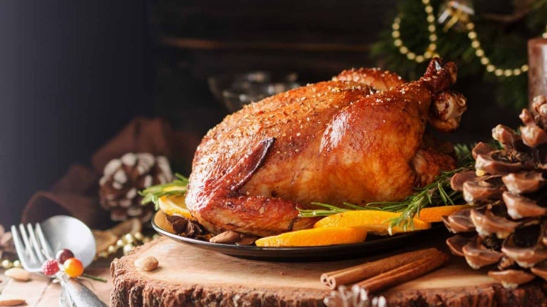 Pavo al horno para la cena de fin de año sobre una mesa temática decorada con elementos rústicos en restaurante