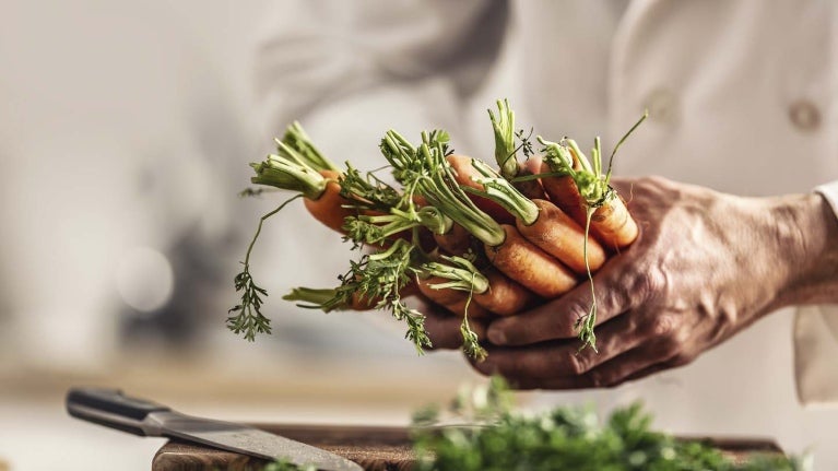 Mano sosteniendo zanahorias