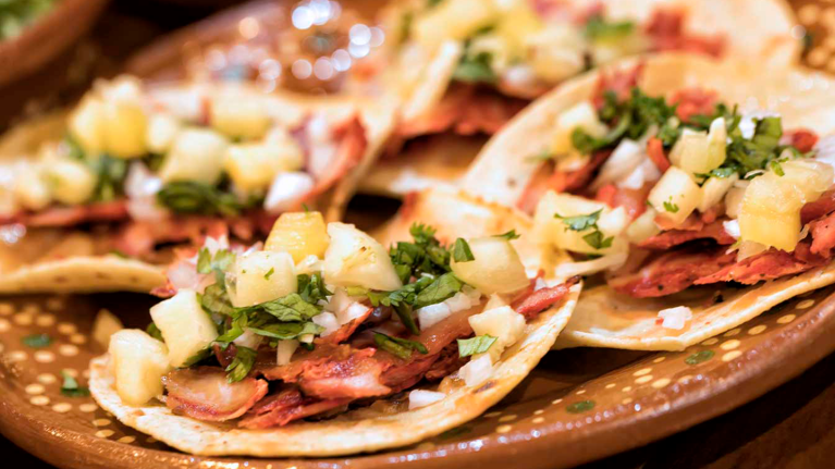 Tacos al pastor en una mesa, un famoso plato latinoamericano