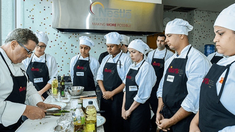 Estudiantes del Programa YOCUTA observan el trabajo de un chef de NESTLÉ PROFESSIONAL® guiando una clase