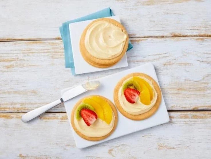 Plato con galletas untadas con Leche Condensada LA LECHERA® y decoradas con durazno, kiwi y fresa