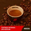 Taza de café nescafé rodeada de granos