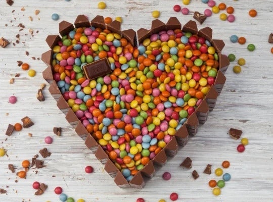 Torta de chocolate con LENTEJAS® Mini coloridas en forma de corazón sobre una mesa