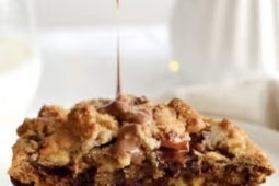 Dos mitades de Galletas de avena y chocolate KITKAT® sobre las que se vierte Untable KITKAT®