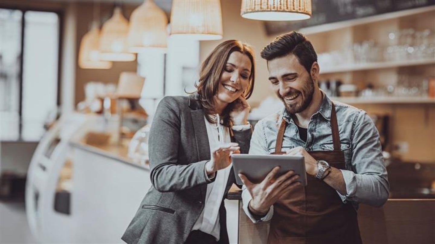 Asesor de Nestlé Professional compartiendo recursos digitales con un dueño de cafetería.